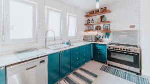 Modern kitchen with blue cabinet paint color trends in Florida featuring professionally painted cabinets with a smooth spray finish